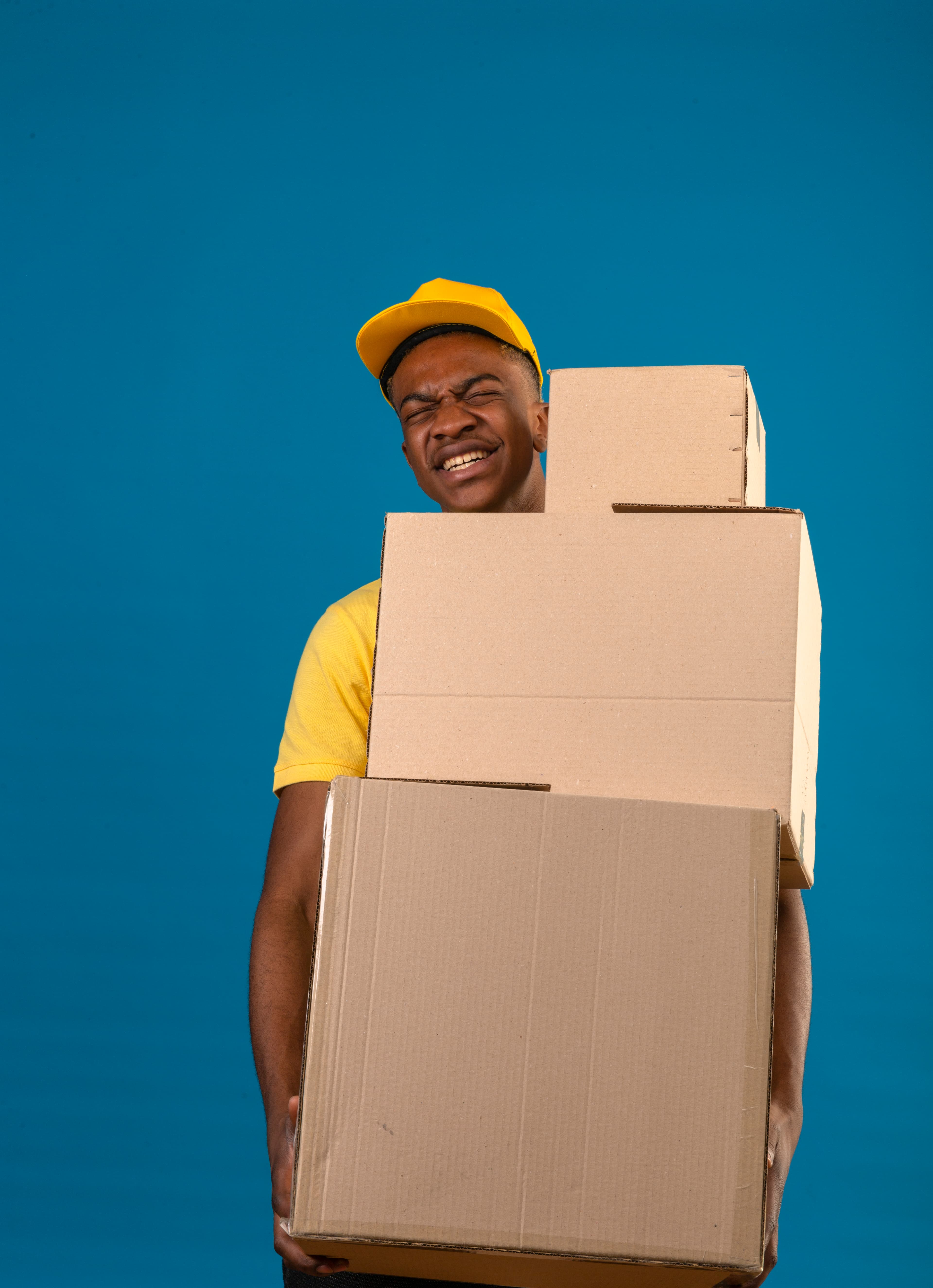 black female courier carrying packages looking delivery address city